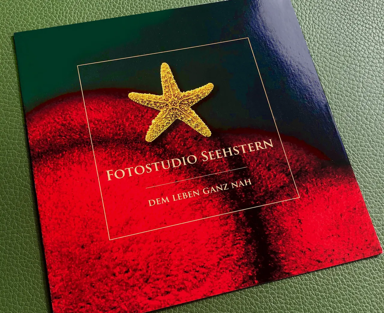 Titelseite des Imagefolders von Fotostudio Seehstern mit goldenem Seestern auf rotem Grund
