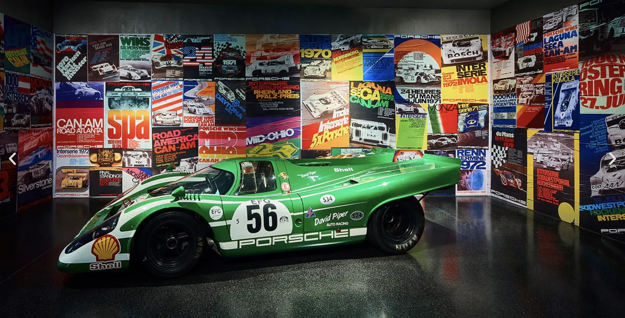 Grüner Porsche 917 vor einer Wand aus Rennplakaten bei Colors of Speed
