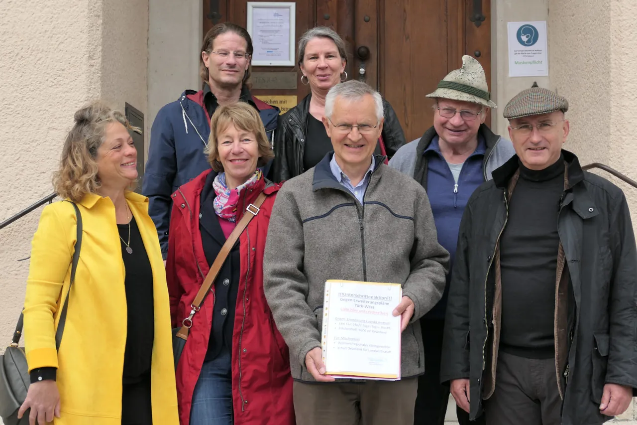 Mitglieder des Vereins mit der Unterschriftenliste vor einem Gebäude