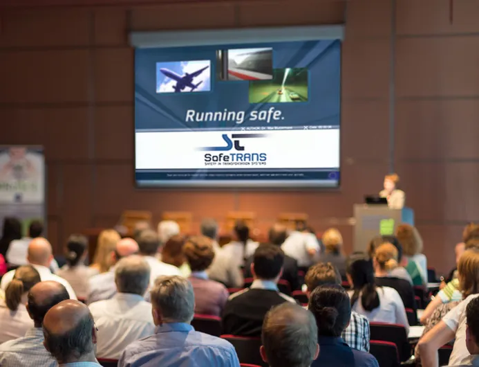 Vortrag vor Publikum mit der Präsentationsfolie Running safe.