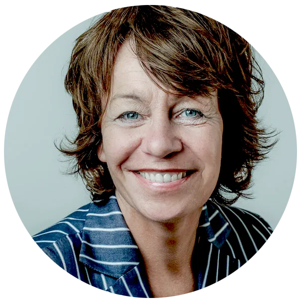 Porträt von Juliane Sachse, lächelnd vor hellem Hintergrund